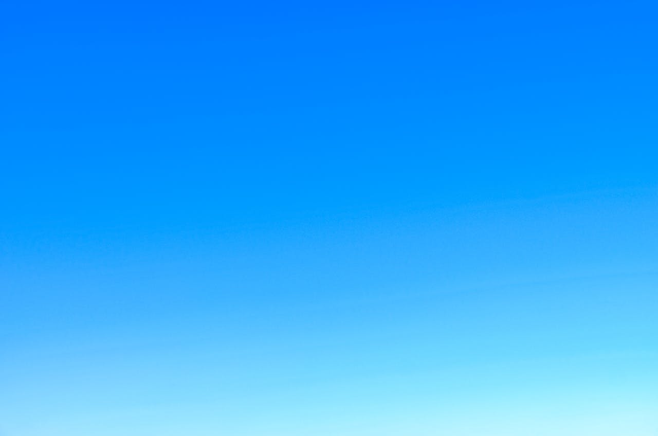 A serene view of a vibrant clear blue sky with a subtle gradient, perfect for backgrounds.